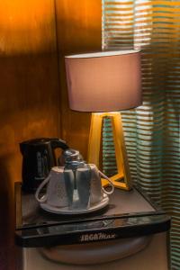 a table with a lamp and a tea kettle on it at Matira house in Bora Bora