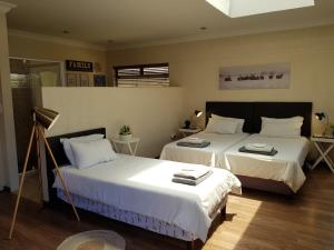 um quarto com 2 camas e lençóis brancos em Vogelstrand Holiday House em Swakopmund