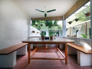 邦劳阿罗那盖克旅馆的一间带桌子和长凳的用餐室
