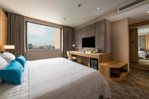 a hotel room with a bed and a desk with a television at Hanoi Hotel in Hanoi +50 photos