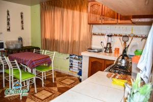 a kitchen with wooden cabinets and a table and chairs at Olimpo Inn in Puno