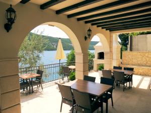 a patio with tables and chairs and a view of the water at Guest House Villa Maslina Neum in Neum