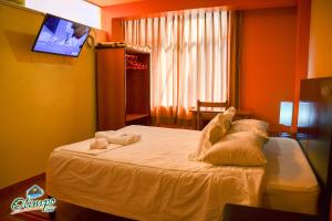 1 dormitorio con 1 cama con 2 almohadas en Olimpo Inn, en Puno
