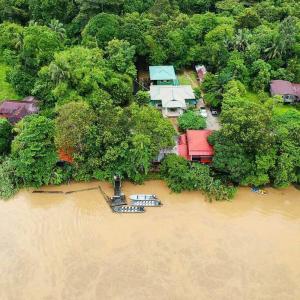 an aerial view of a river with houses and trees at Sukau Greenview Bed & Breakfast in Sukau