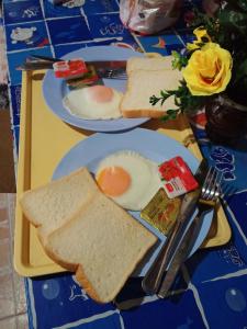 two plates of food with eggs and toast on a table at Poonsap Resort in Ko Lanta