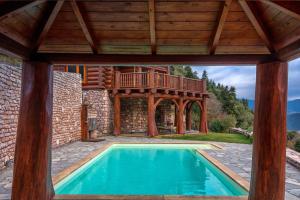 einen Pool in einem Haus mit einer Terrasse in der Unterkunft Mythica Chalet in Karpenisi