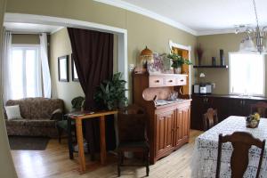 a living room with a table and a dining room at La Grange aux Hiboux Gîte et Restaurant B&B in La Baie +12 photos