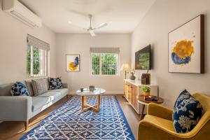 a living room with a couch and a table at amã Stays & Trails, Braganza House in Candolim