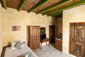 a bedroom with a bed and a tv in a room at Cozy Rooms Goreme in Goreme