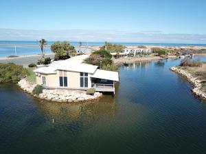 a house on an island in the water at Pelican Point Waterfront Resort formerly Carnarvon Beach Retreat in Carnarvon