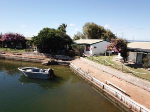 two boats are docked in the water near a house at Carnarvon Beach Retreat in Carnarvon