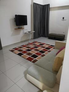 a living room with a couch and a tv at Homestay An-nur in Alor Setar