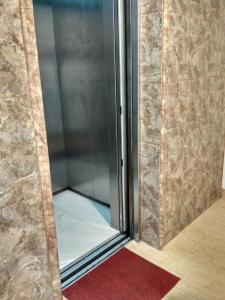 a shower in a room with a red carpet at Cordex Oase Pekanbaru in Pekanbaru