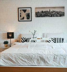 a bedroom with a white bed and a table at The Peem Hotel in Ban Na