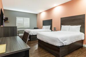 Postel nebo postele na pokoji v ubytování Scottish Inns & Suites Houston, TX
