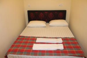 a bed with two pillows and two towels on it at Green Palace Colombo in Colombo