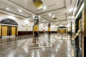 einen großen Saal mit einer Lobby mit Türen und einem Gebäude in der Unterkunft Crystal Crown Hotel Harbour View, Port Klang in Klang