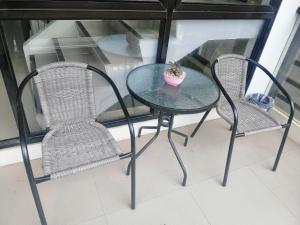 a glass table with two chairs and a plant on it at Casa Coron Hotel in Coron