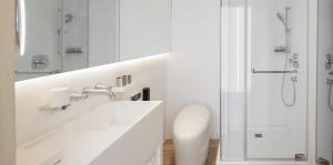 un bagno bianco con lavandino e doccia di Swiio Hotel Daan a Taipei
