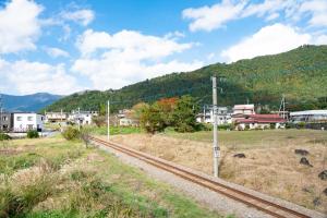 ein Zug auf den Gleisen in einer Kleinstadt in der Unterkunft Private House Clover in Fujikawaguchiko