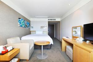 a hotel room with a bed and a couch and a tv at Best Western Premier Incheon Airport Hotel in Incheon