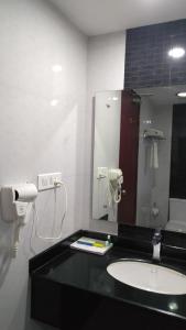 a bathroom with a sink and a mirror at Rouba Residency Hotel in Ponnāni