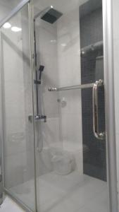 a shower with a glass door in a bathroom at Rouba Residency Hotel in Ponnāni