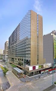 un gran edificio de cristal con un tren delante de él en The Kowloon Hotel, en Hong Kong