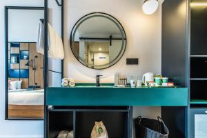 a bathroom with a blue sink and a mirror at Campanile Shanghai Huaihai in Shanghai