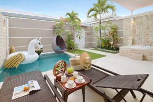 a villa with a swimming pool and a patio at Bali Cosy Villa Adults Only in Legian