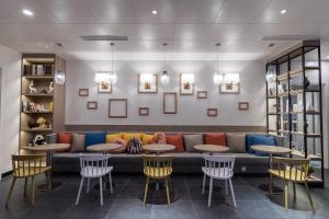 a lobby with a couch and tables and chairs at Campanile Shanghai Huaihai in Shanghai