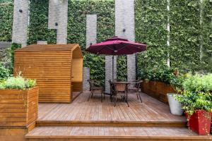 a wooden deck with a table and an umbrella at Campanile Shanghai Huaihai in Shanghai +37 photos