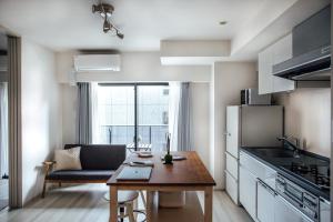 Una pequeña cocina con una mesa y un sofá. en Dash Living Nihonbashi, en Tokio
