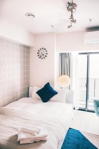 a bedroom with two beds and a clock on the wall at Dash Living Nihonbashi in Tokyo