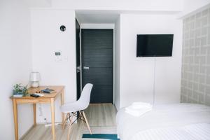 a bedroom with a bed and a desk and a chair at Dash Living Nihonbashi in Tokyo