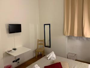 Un dormitorio con una cama, un espejo y una silla. en Gabriele 83, en Turín