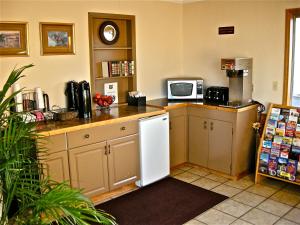 a kitchen with a white refrigerator and a microwave at Knights Inn - Baker City in Baker City