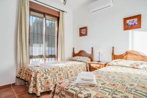 ein Schlafzimmer mit zwei Betten und einem Fenster in der Unterkunft Casa Villanueva 1 -sólo Familias in Hozanejos + 19 Fotos