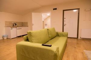 un soggiorno con divano verde e telecomando di A Apart Hotels Ankara Beytepe a Ankara