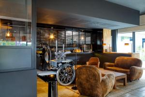 歐什的住宿－Le Domaine de Baulieu，客厅配有椅子、桌子和机器