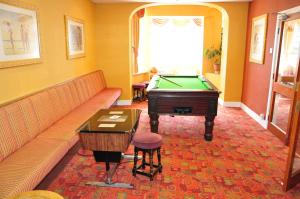 a living room with a couch and a pool table at Silversands Hotel in Blackpool