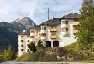 budynek na wzgórzu z górą w tle w obiekcie Hotel Goldried w mieście Matrei in Osttirol