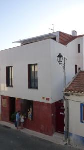 two people standing outside of a white building at Born To Stay In Milfontes in Vila Nova de Milfontes