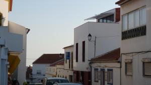 a city street with buildings and cars on the road at Born To Stay In Milfontes in Vila Nova de Milfontes