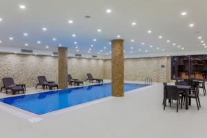 um átrio com piscina, mesas e cadeiras em Shimall Hotel em Gaziantep