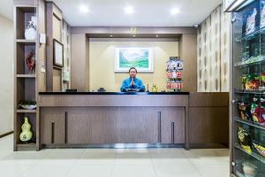 a woman standing behind a counter in a store at OYO 279 Deli Homestay in Medan