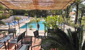 an outdoor patio with chairs and a swimming pool at Résidence Les Pins in Calvi +40 photos