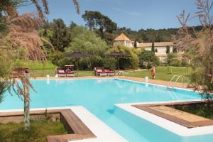 una gran piscina en un patio con árboles en Hotel La Malcontenta, en Palamós
