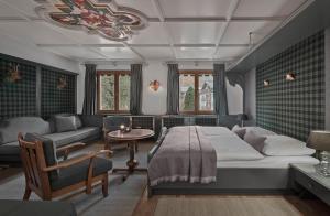 1 dormitorio con cama, sofá y mesa en Hotel Goldener Greif, en Kitzbühel