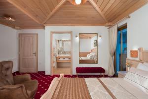 a bedroom with a large bed and a mirror at Hotel Planinka in Ljubno